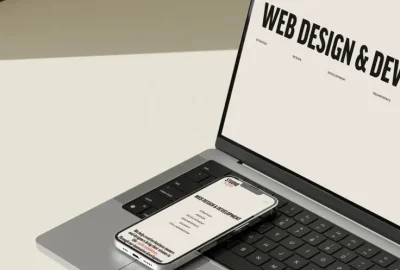 An open silver laptop and phone viewed from side, showing its black keyboard and trackpad. of a digital marketing strategist in Kannur, Kerala.